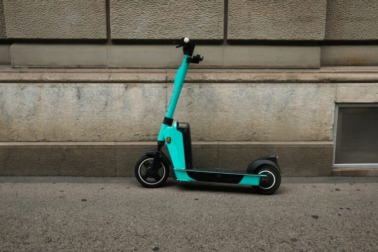 a picture of electronic kickscooter parking at the wall in zurich city